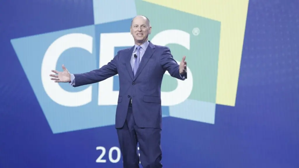 Technology executive presenting on stage in front of a large CES logo backdrop during CES 2026 keynote announcement